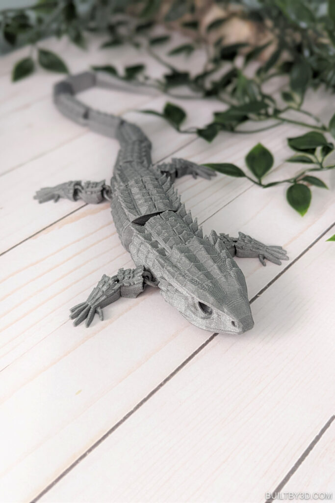 3d print lizard next to greenery.