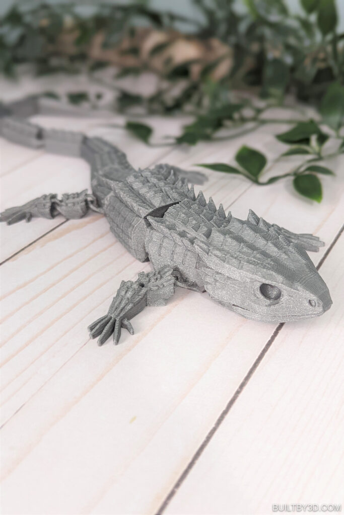 3d print lizard next to greenery.